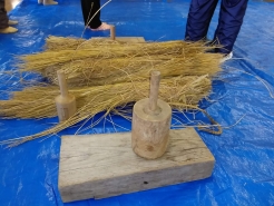 しめ飾り用の青刈り稲を木製のハンマーみたいなやつ。横槌（よこつち）とか藁打槌（わらうちつち）と呼ぶそうです。これで叩くと編みやすくなります。